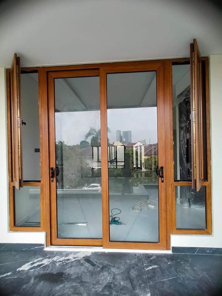 Pintu geser dengan finishing bernuansa kayu dan jendela samping.